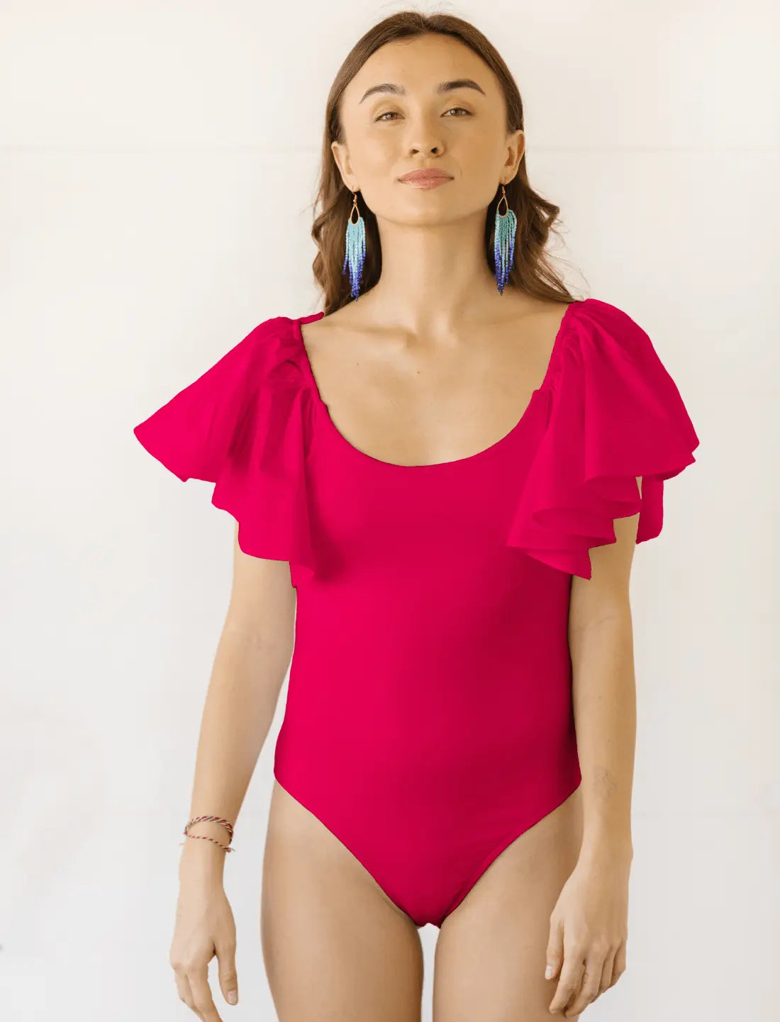A model wears the Ina Bodysuit in the color fuchsia. 